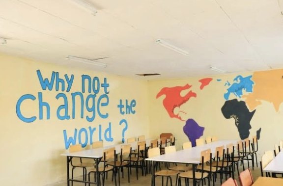 A painted wall asking Why not change the world? beside a colourful world map