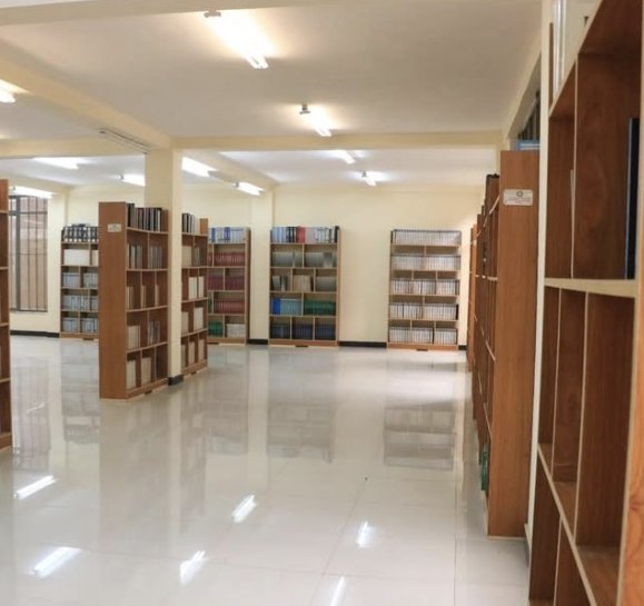 A long aisle of wooden bookshelves at the Lafto library